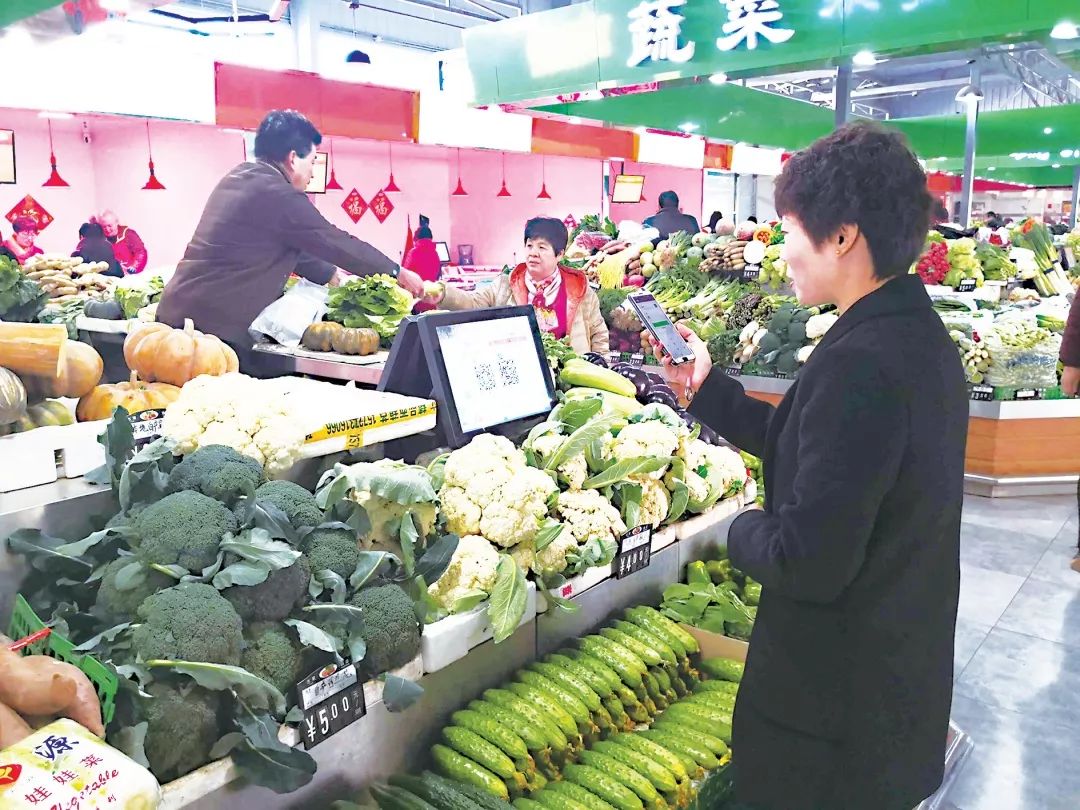 市民在滨河裕龙智慧菜市场通过手机购买蔬菜.